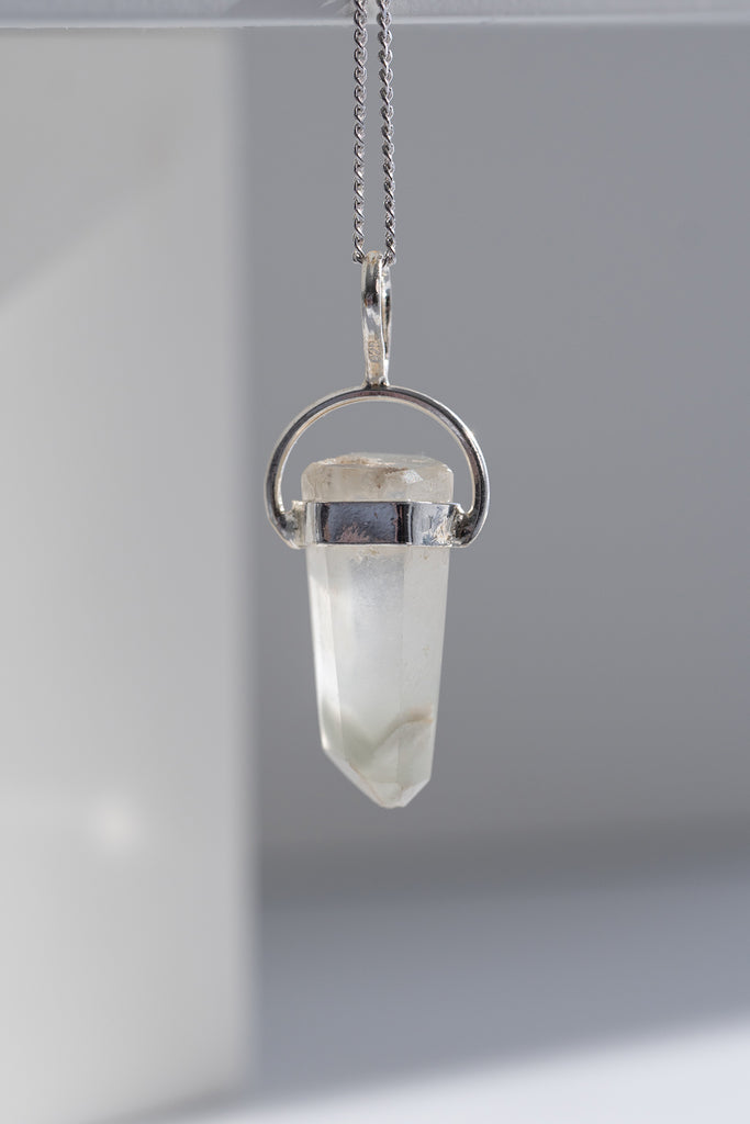 Crystal pendant necklace on a plain background