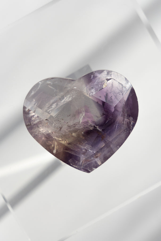 Heart-shaped purple gemstone on a white background