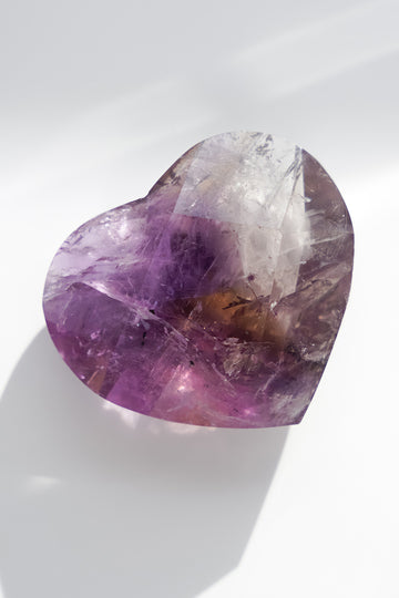 Heart-shaped purple crystal on a white background