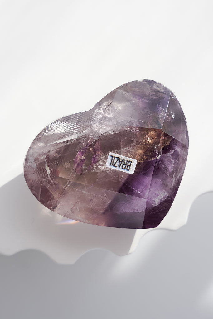 Heart-shaped purple crystal with 'BRASIL' label on a white background