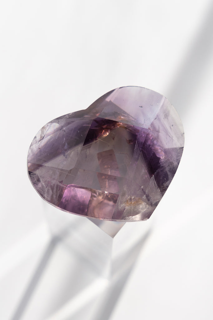 Heart-shaped purple gemstone on a white background
