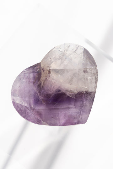 Heart-shaped amethyst crystal on a white background