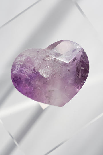 Heart-shaped purple crystal on a white background