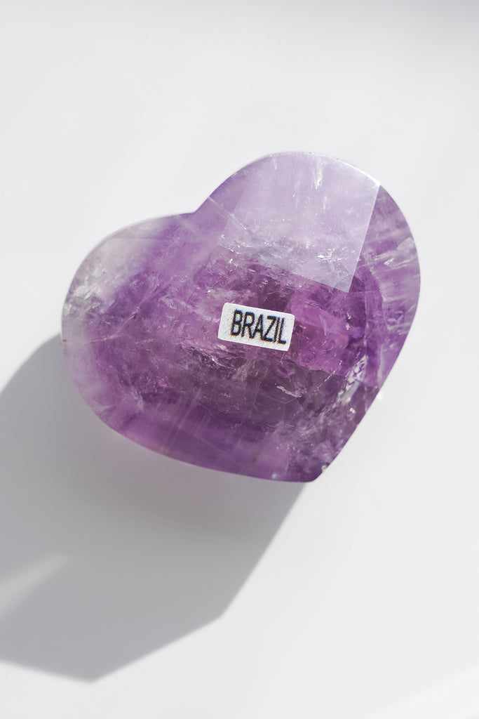 Heart-shaped purple crystal with 'BRAZIL' label on a white background