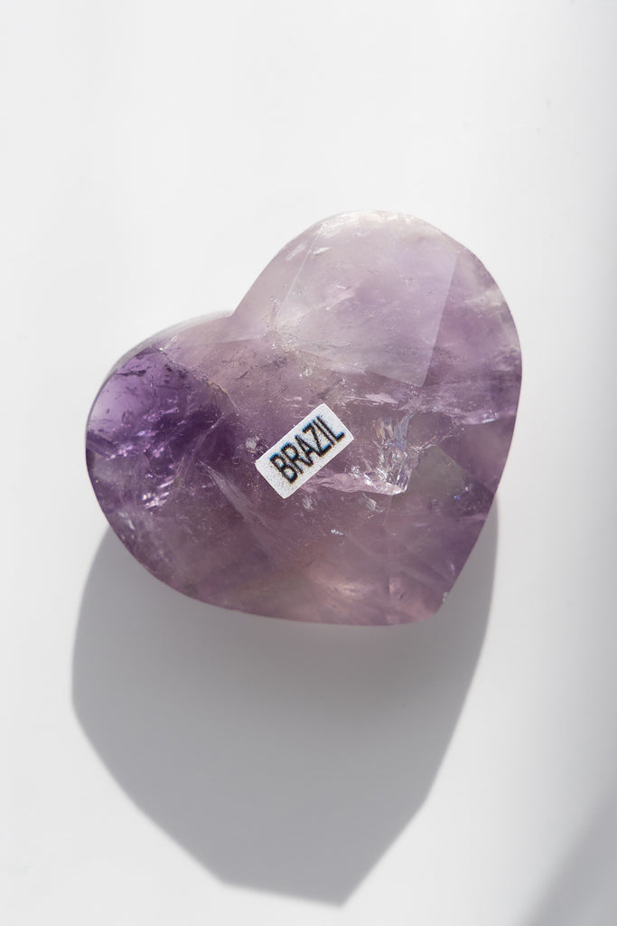 Heart-shaped purple crystal with 'BRAZIL' label on a white background