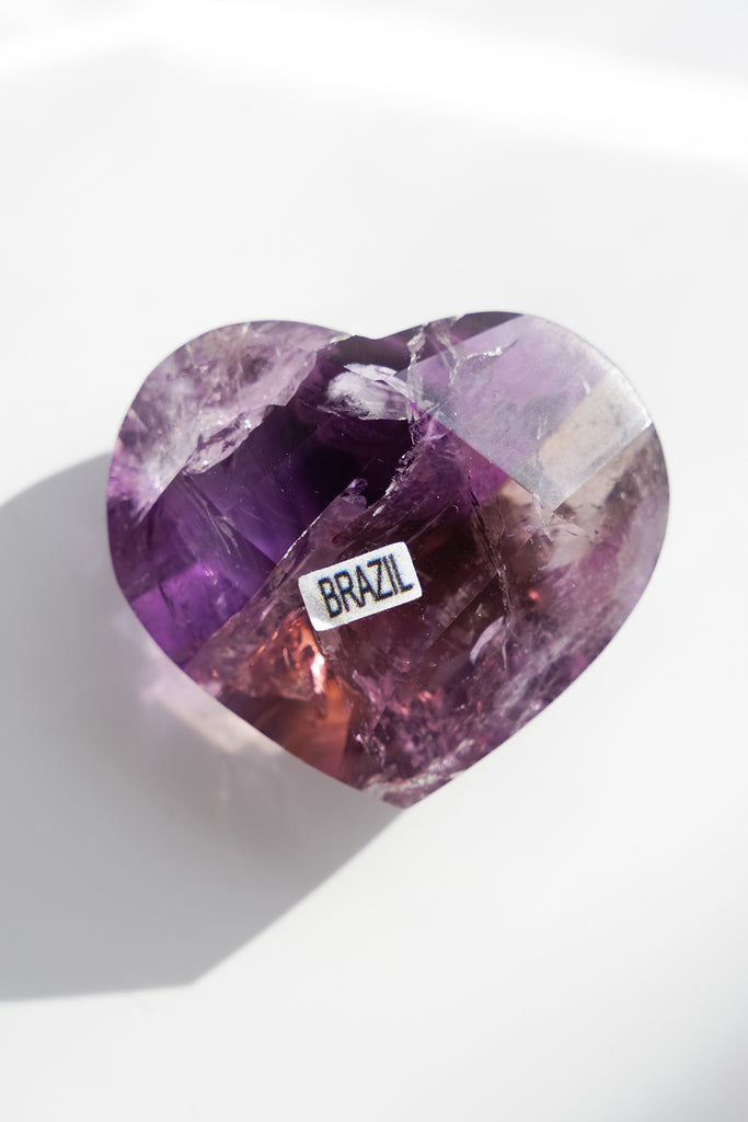 Heart-shaped purple gemstone with 'BRAZIL' label on a white background