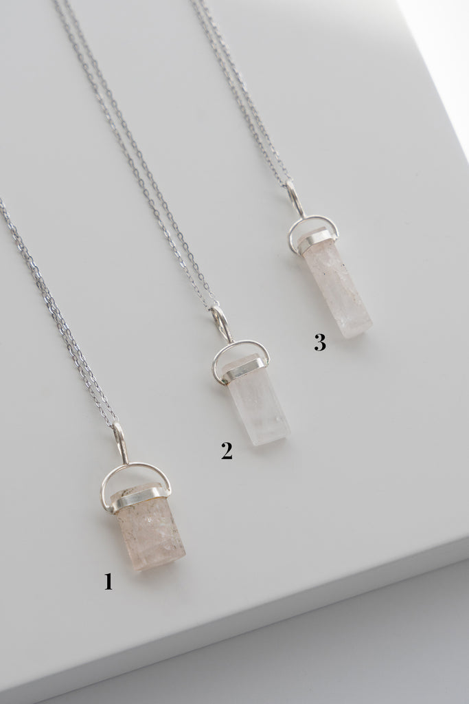 Three crystal pendants on silver chains with numbers indicating their order.