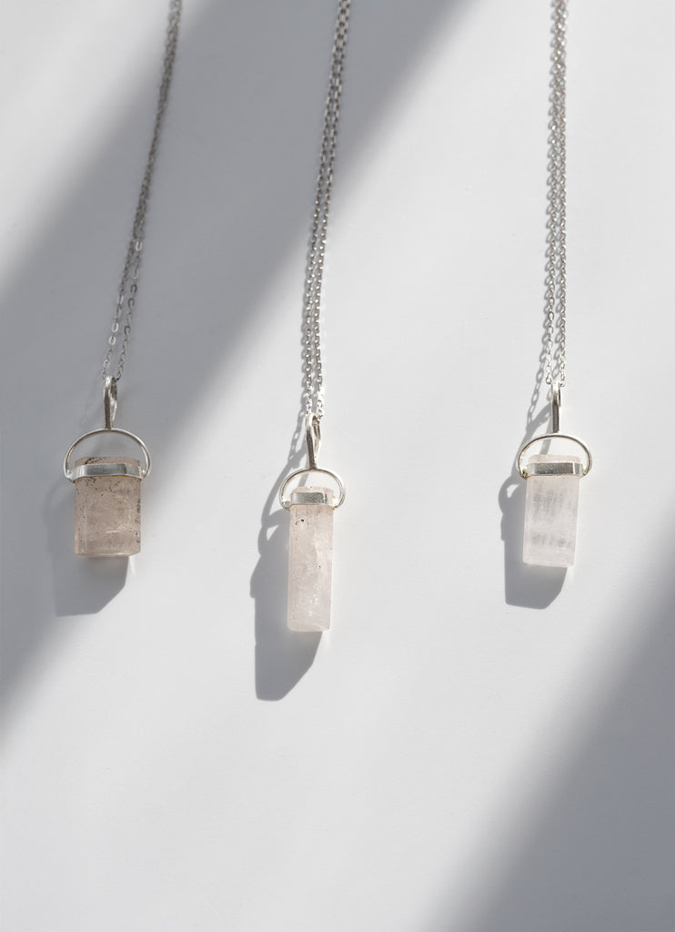 Three crystal pendant necklaces on a white background